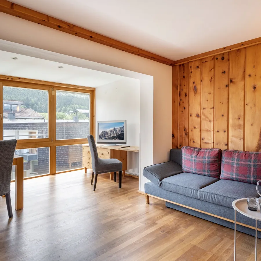 Wohnraum mit Zirbenholzwand, Sofa und Essplatz im Superior Studio Top 23