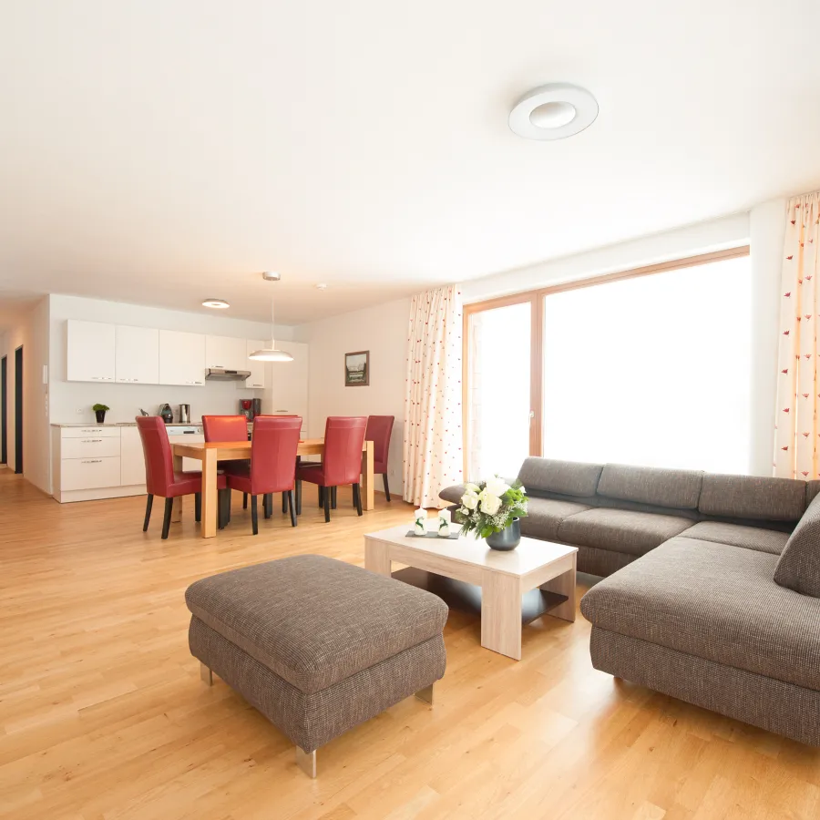 Wohnküche mit Esstisch und Ecksofa im Apartment mit 2 Schlafzimmern und Garten