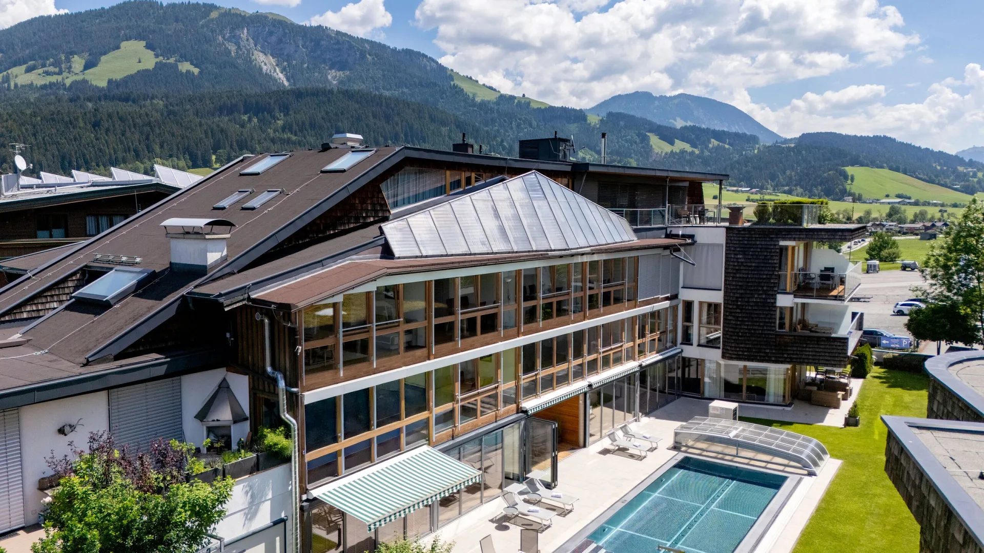Luftaufnahme des Martinshofs mit Poolbereich und Bergpanorama