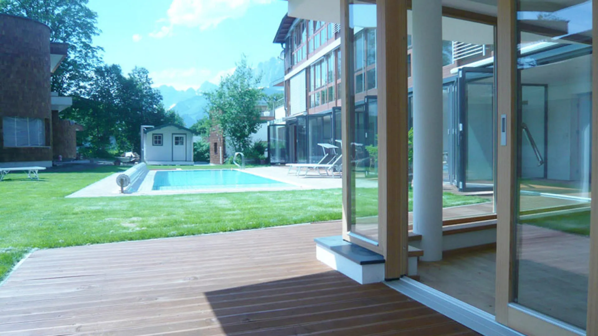 Blick aus dem Wintergarten auf Garten und Pool