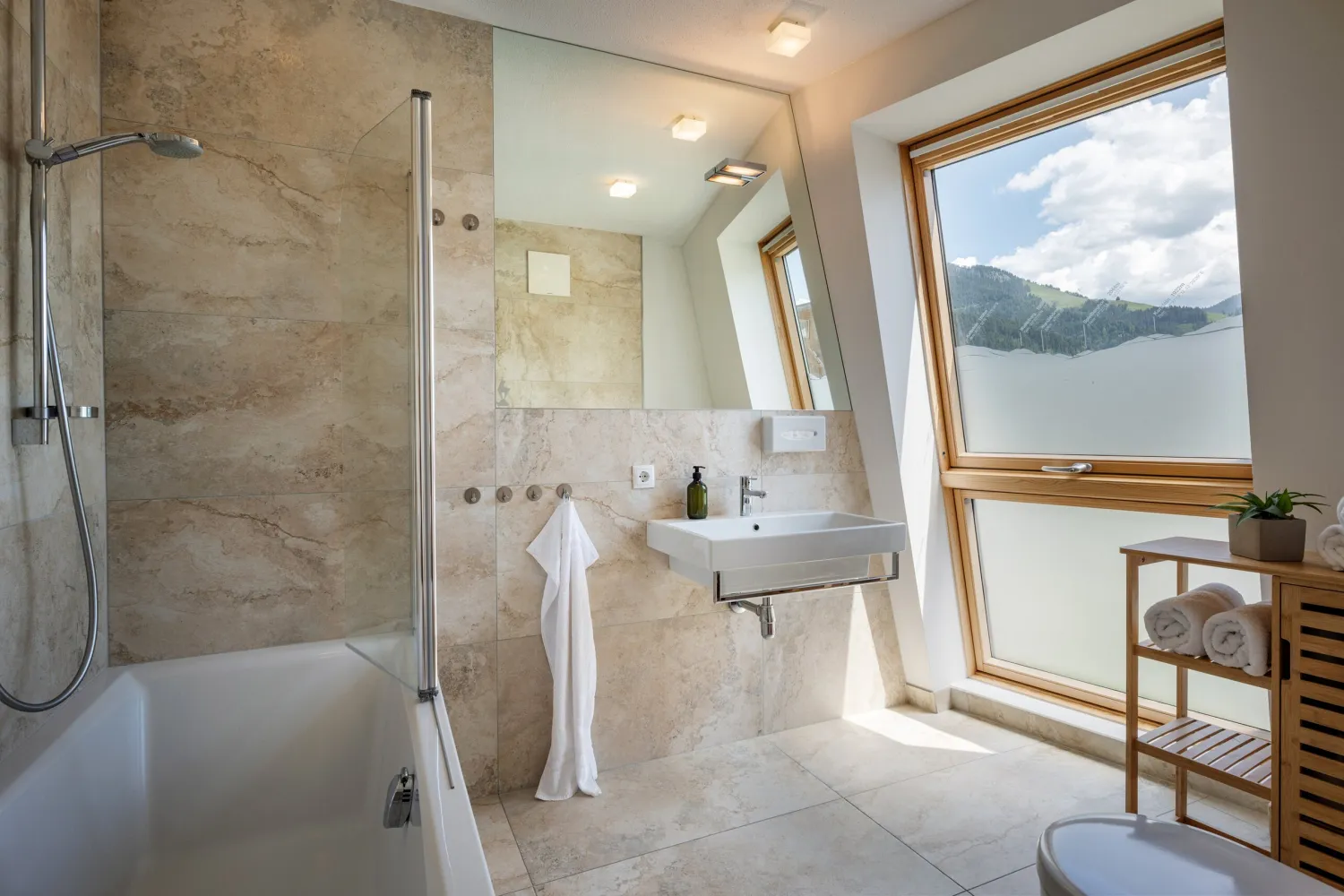 Badezimmer mit Badewanne und Waschtisch im Apartment Top 26