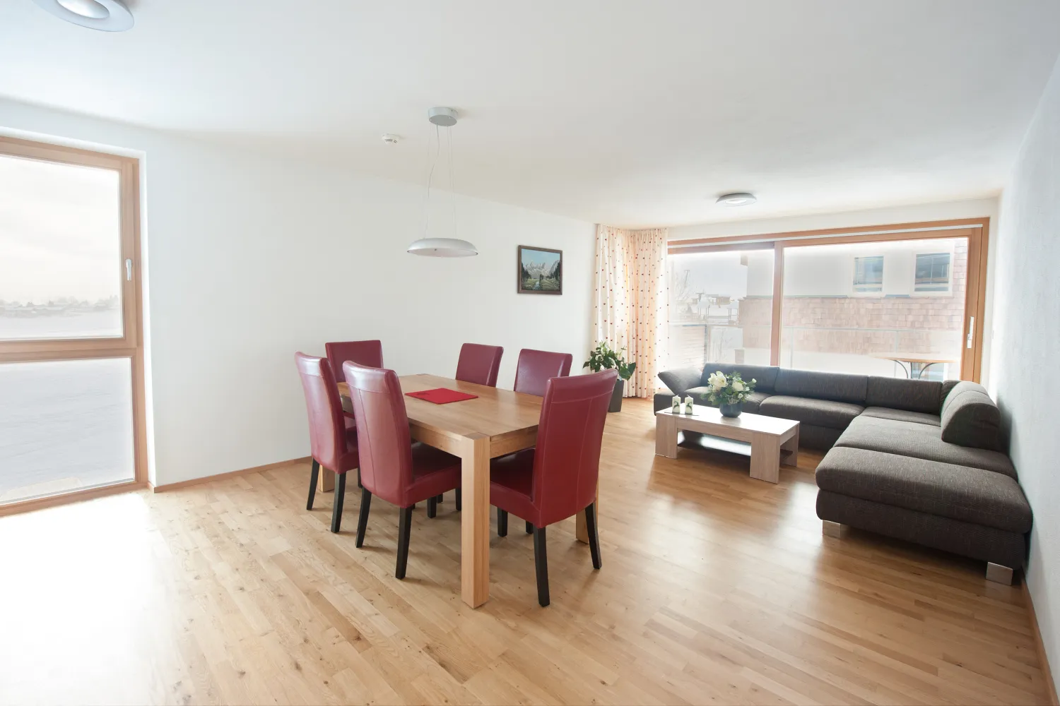 Wohnküche mit Esstisch und Sofa im Apartment mit 2 Schlafzimmern und Balkon
