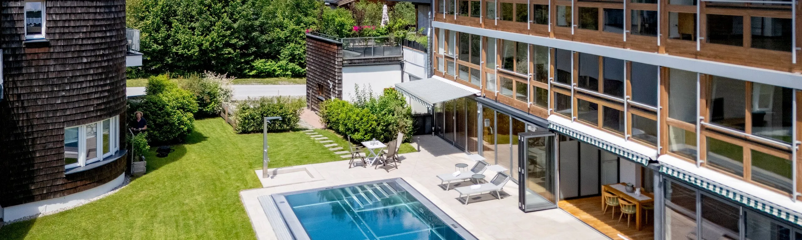 Poolbereich des Martinshofs von oben, im Hintergrund der Wilde Kaiser