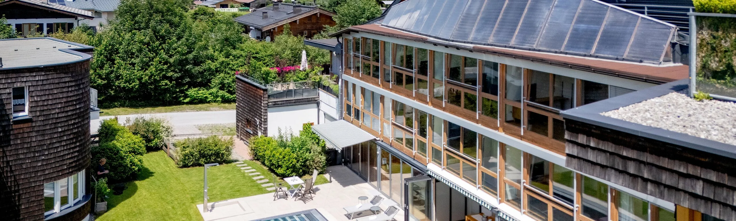Apartmenthaus Martinshof mit Pool und Liegewiese vor dem Wilden Kaiser